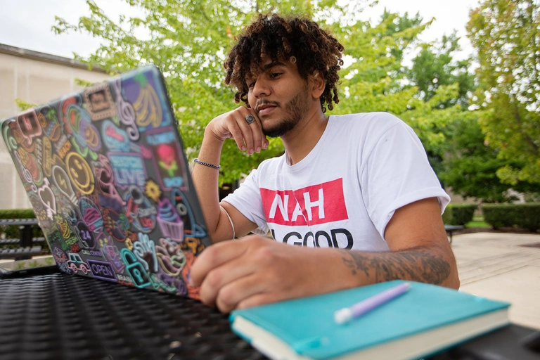 A student doing homework on campus.