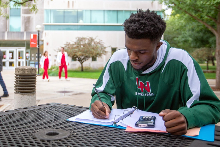 Student doing homework outside of campus.